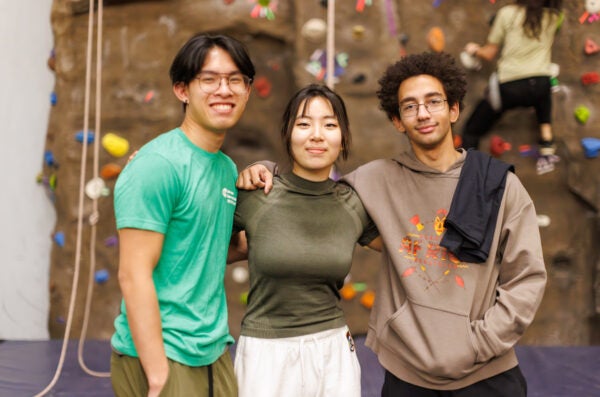 Three students pose with arms around each other at RecLive