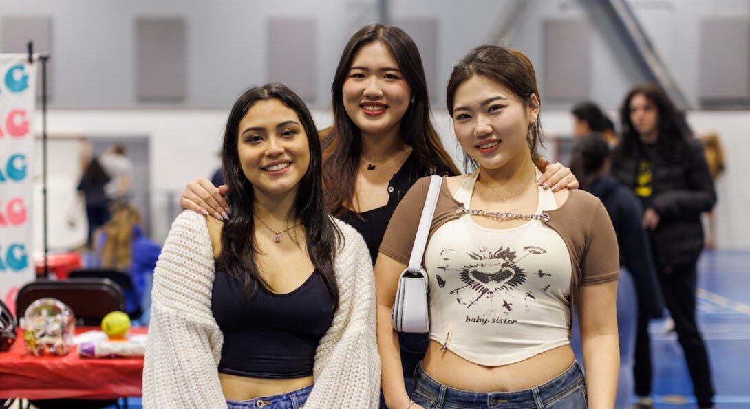 Three students posing with arms around each other at Rec LIVE